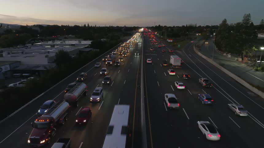 Heavy traffic flows along controlled access highway after dusk