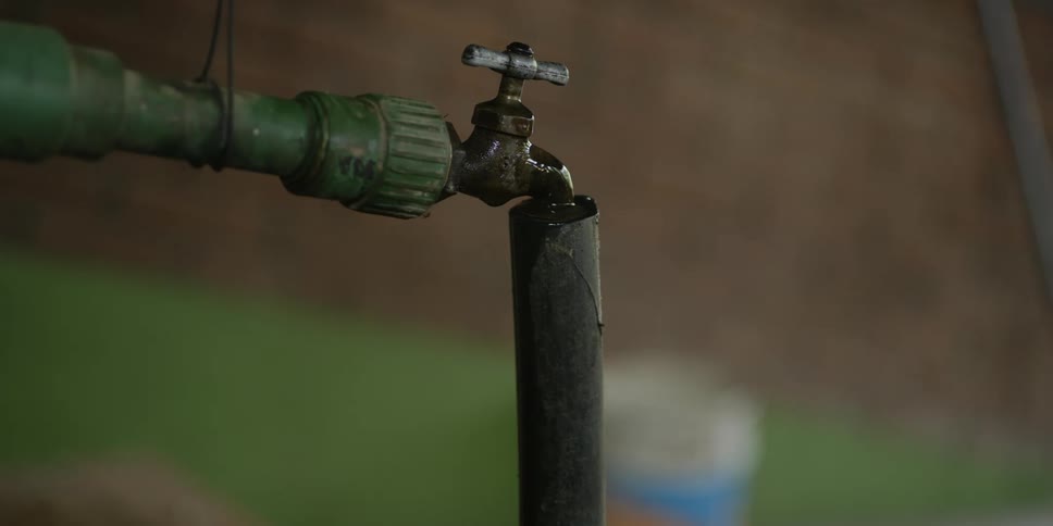 A leaking outdoor faucet with a connected hose