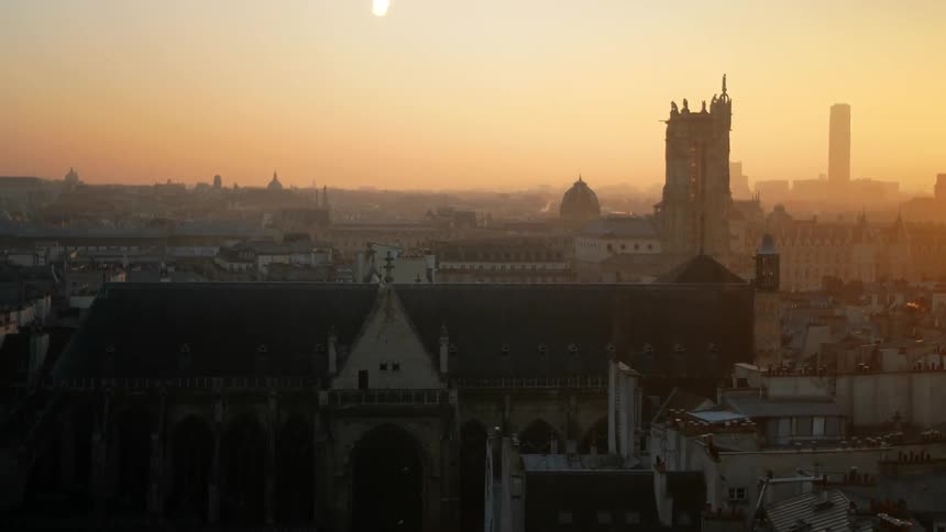 The orange glow of a sunrise washes over an old city
