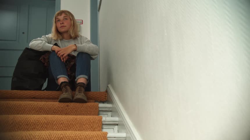A woman sitting at the top of a staircase