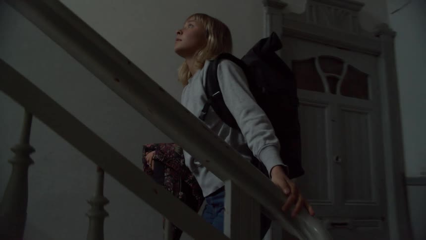 A woman is climbing the stairwell with her luggage