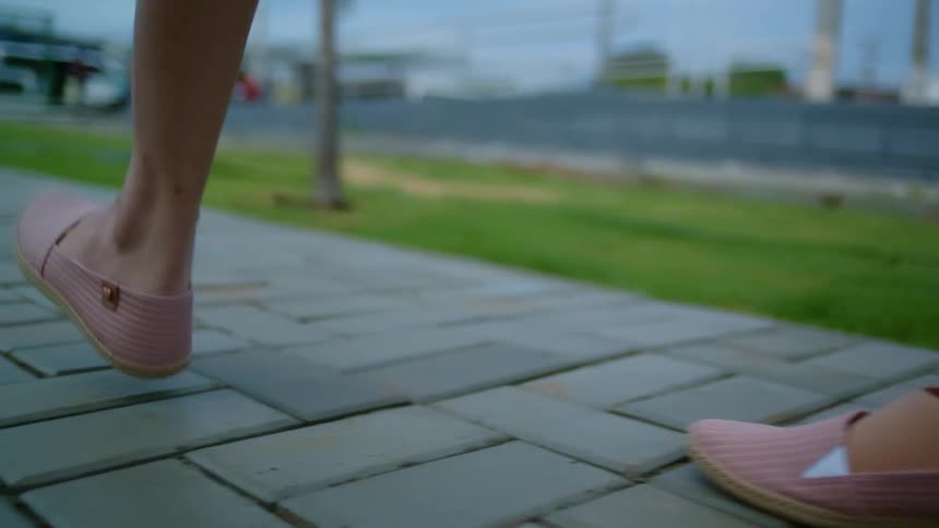 Woman with prosthetic leg walks along walkway in town