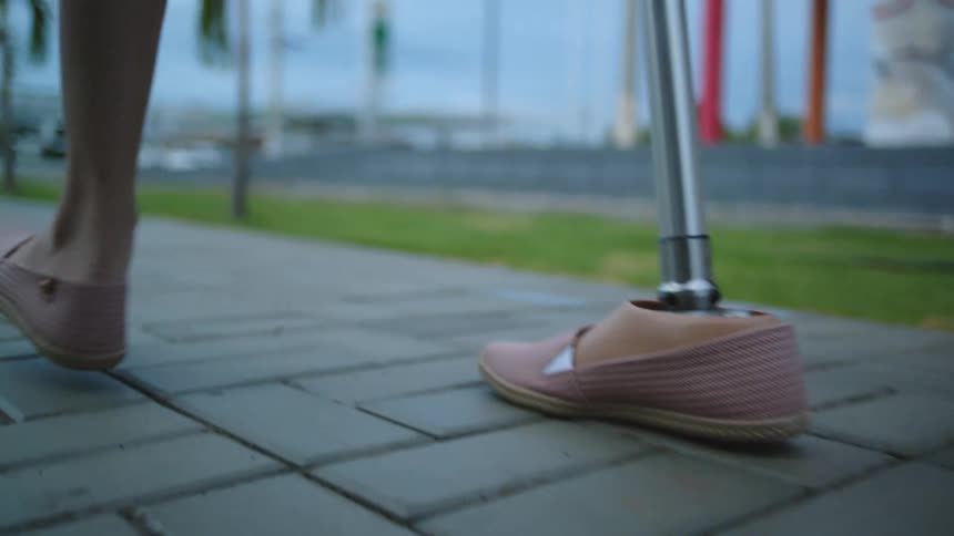 A woman with a prosthetic leg walks down the sidewalk