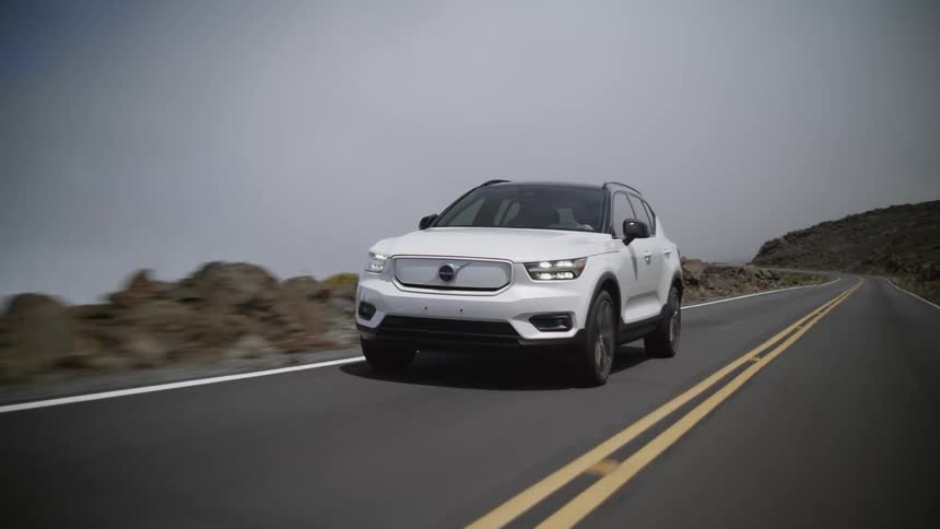 A white volvo xc40 electric suv traveling on an empty rural road