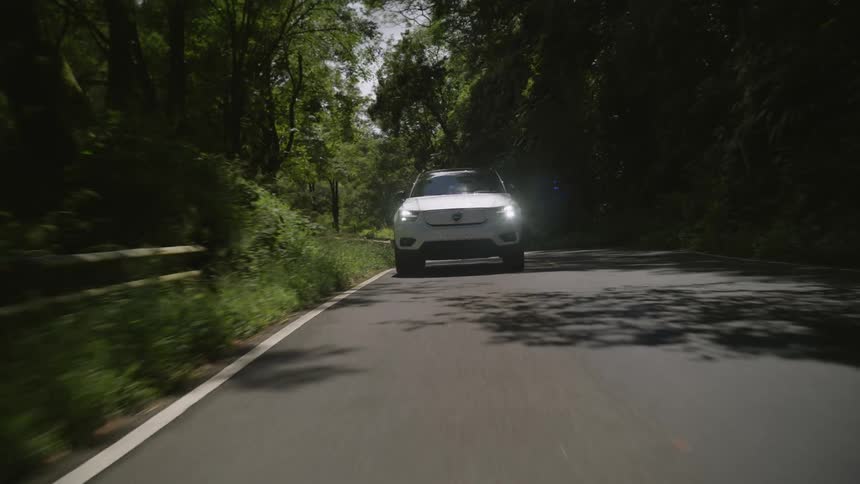 A car is driving on the winding road