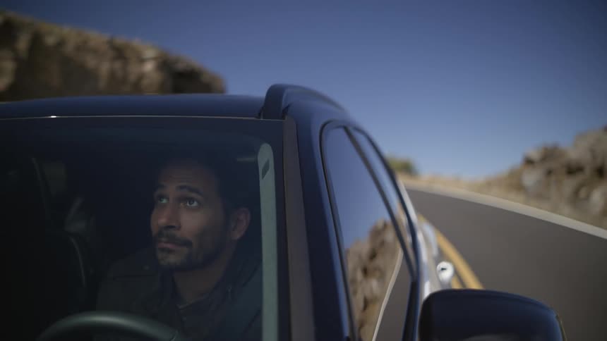 A man takes in the scenery while driving down a rural highway