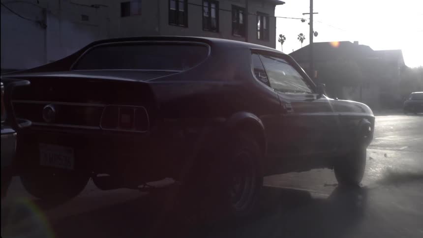 A car is parked on the street as another passes
