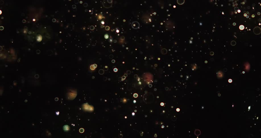 Hundreds of small spheres shimmer against a black background