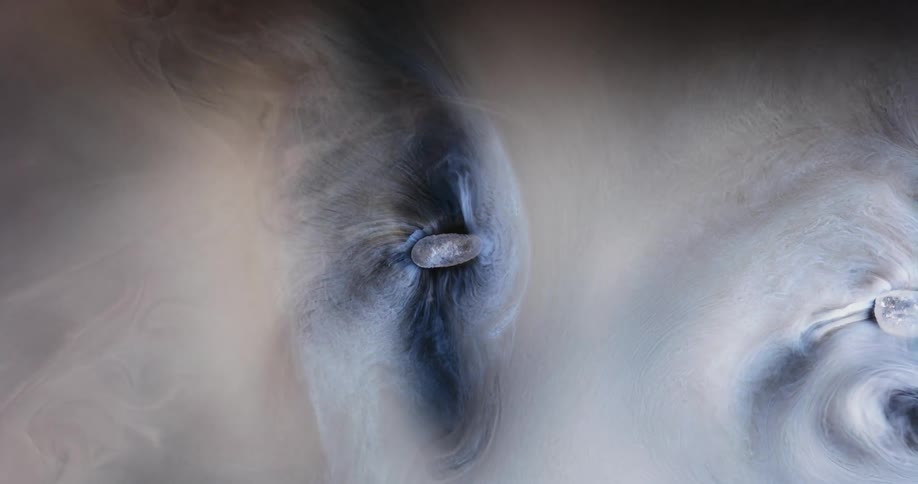 A white substance flows as it spins and sprays mixing with the blue