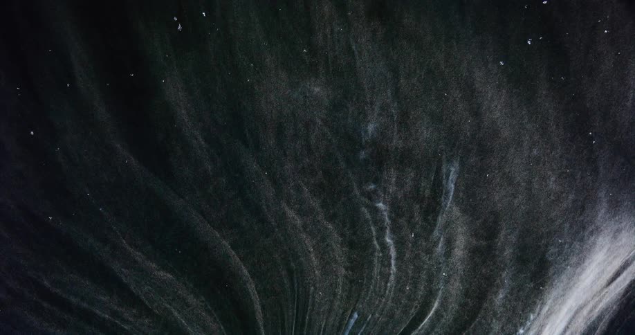 Streaks of white smoke rising upwards in darkness