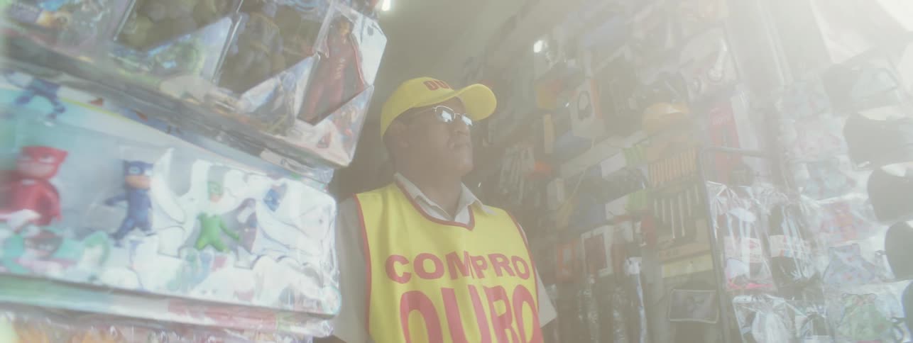 An older man is walking inside of a store in the day time