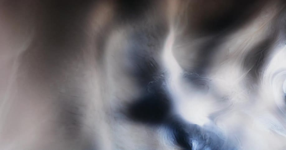 A smoky swirl pattern moves in front of a black background