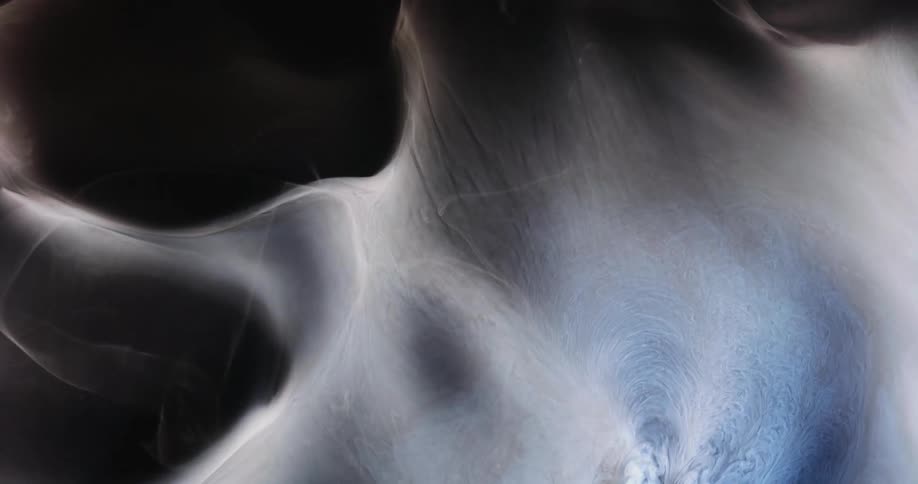 A white smokey substance moves as wisps stretch across the darkness