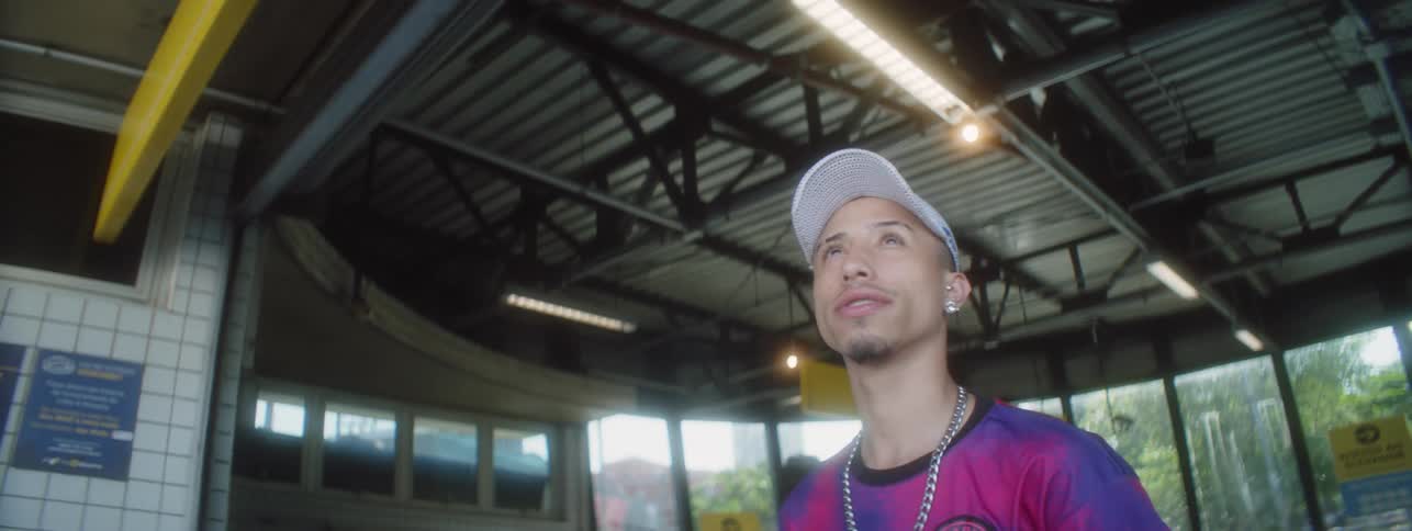A man wearing a cap is walking out of the subway and is surprised at what he sees looking up to the street