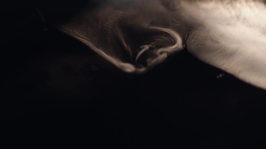 Swirls of white smoke moving in darkness