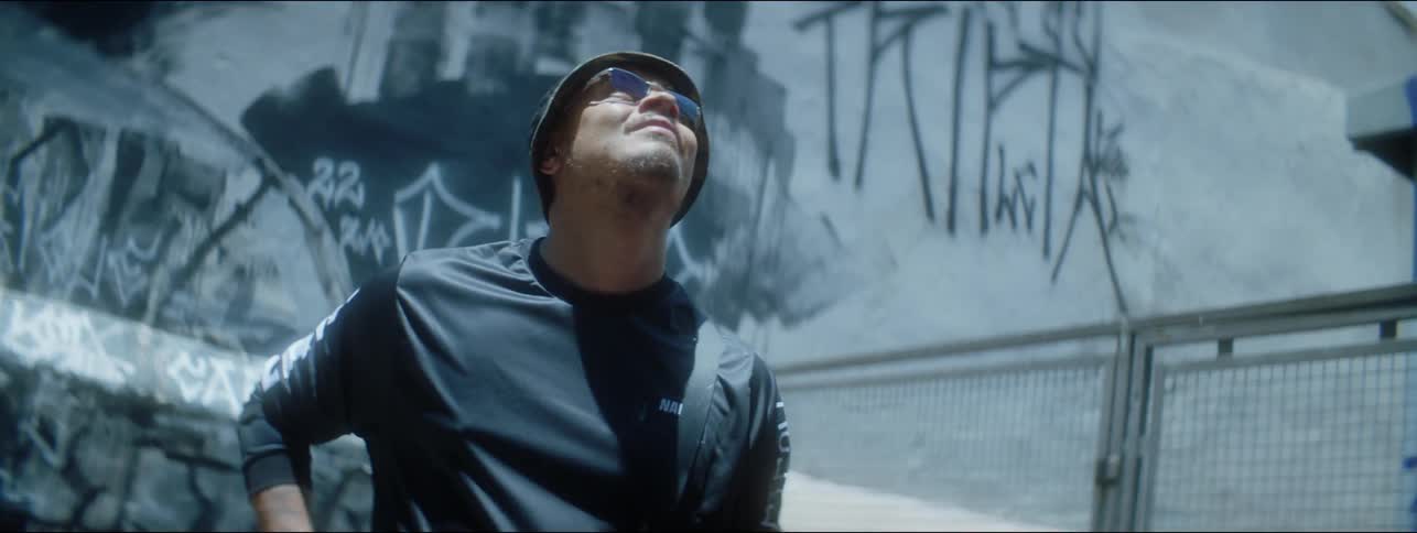 A man is looking up impressed at a graffitti wall around an alley