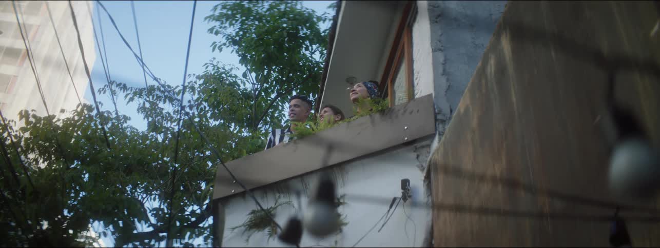 People are outdoors on a balcony and looking around in the day time