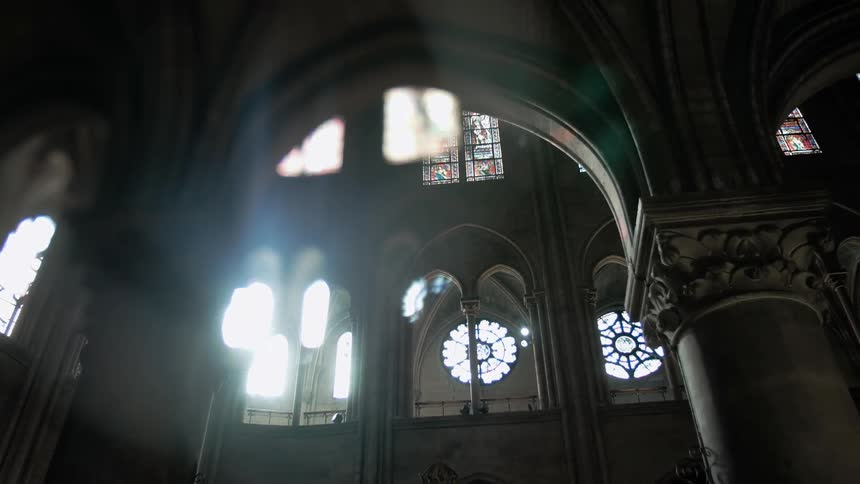Sunlight streaming through the stained-glass windows of a large church
