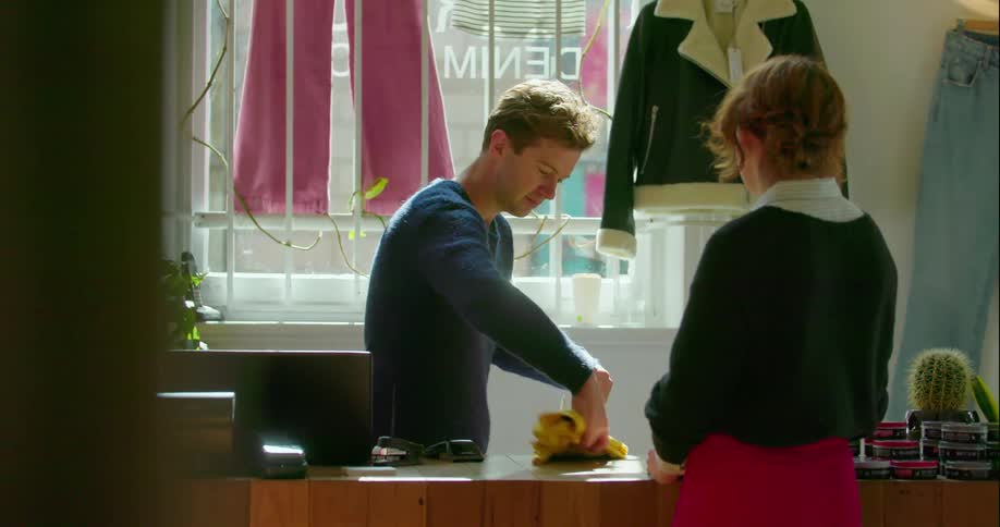 Man places a customer's clothing purchase into a bag