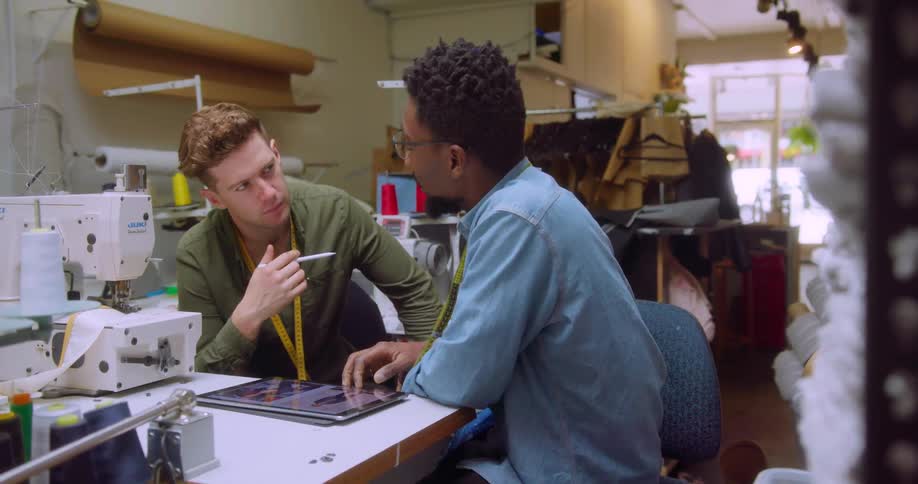 Two clothing designers converse with each other