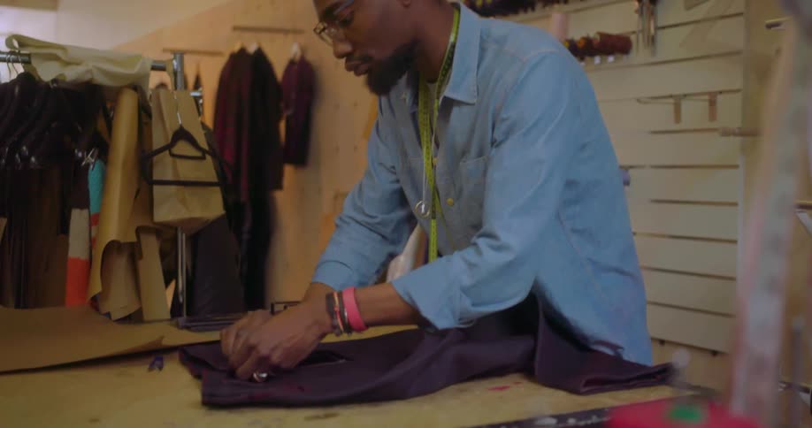 A man adjusts fabric in a clothes shop