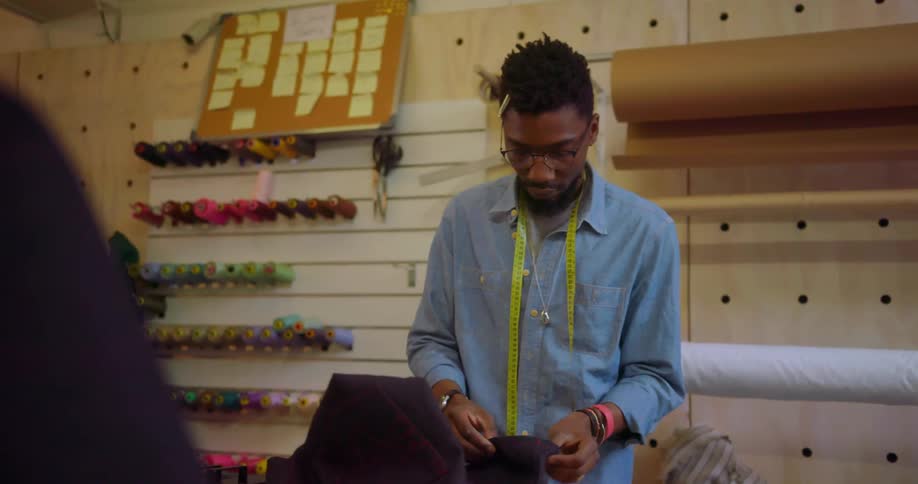 A clothes maker works with a piece of fabric