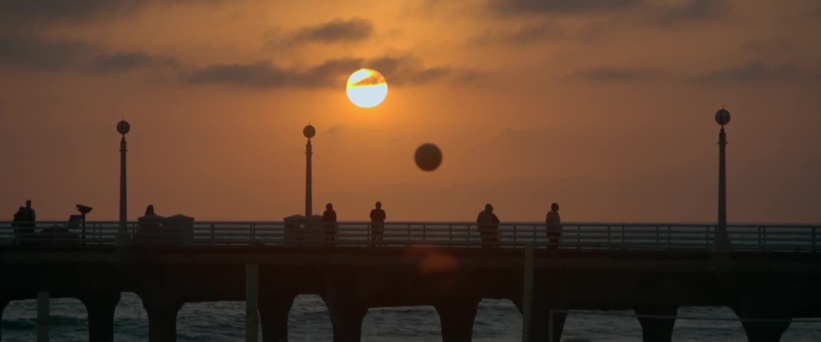 People stand on a pier on the beach