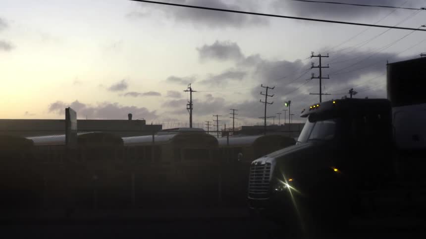 A truck drives down a road on a cloudy day