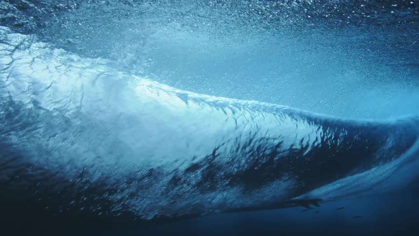 Underwater footage of an ocean wave rolling overhead at daytime