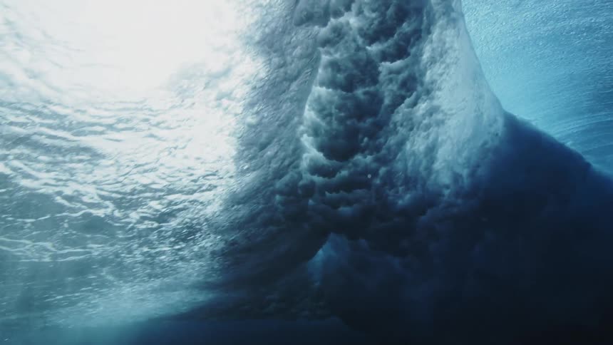 Underwater footage of an ocean wave rolling overhead at daytime