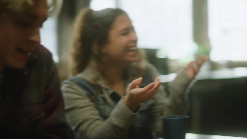 A small group of people are sitting at a table talking and laughing