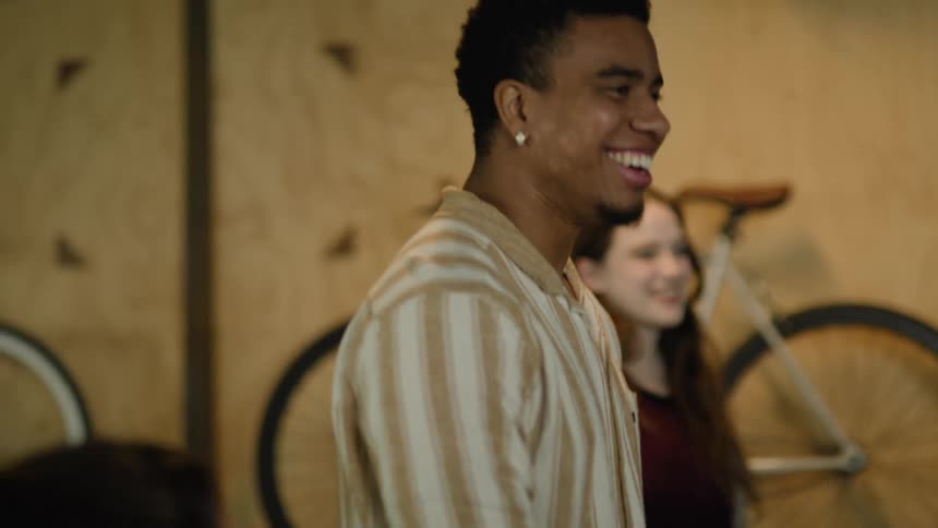 A group of friends laugh while hanging out in a garage