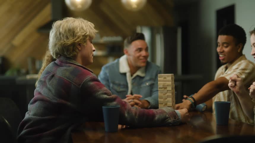 A group of friends playing jenga on a table