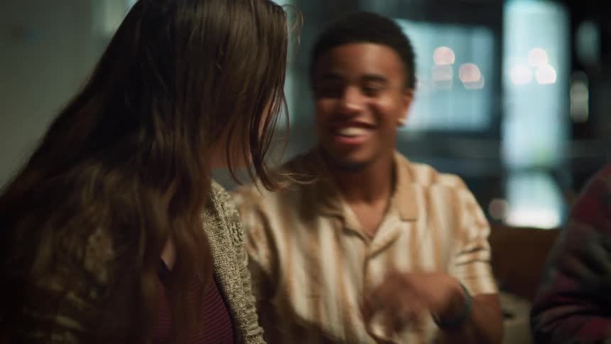 A teenage boy and girl trade secret and jokes flirting with each other