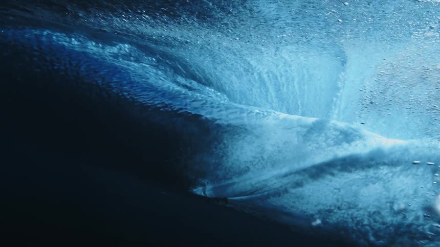 A man surfs as a large wave goes over him and he goes under the water