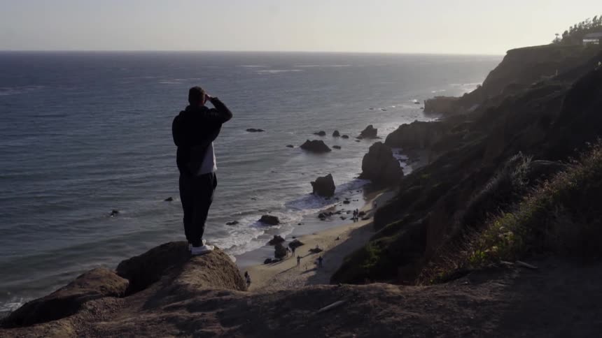 A man takes pictures of the ocean
