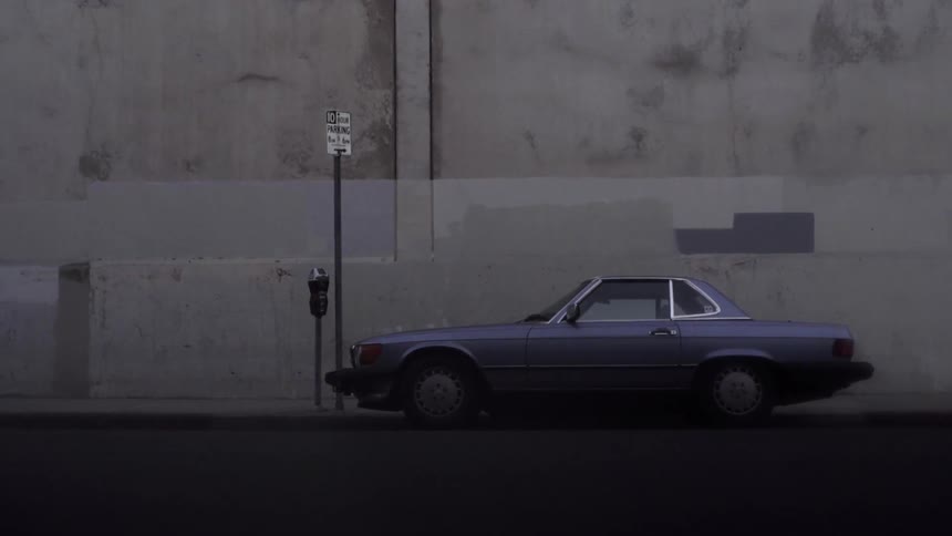 A car is parked beside a building