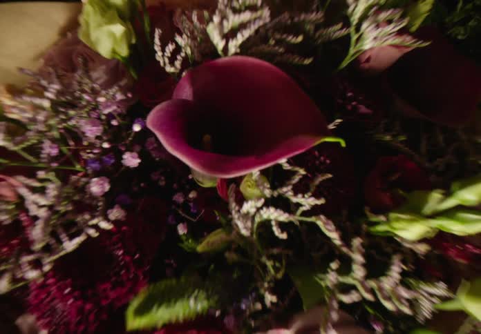 Woman holds bouquet full of pink and purple flowers