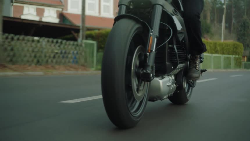 A motorcyclist rides a motorcycle through a town during the day