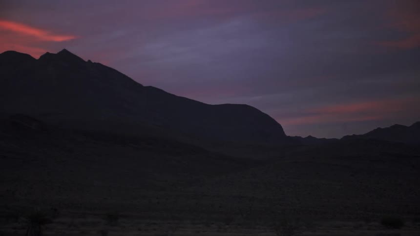 The hills are dark as the sun sets