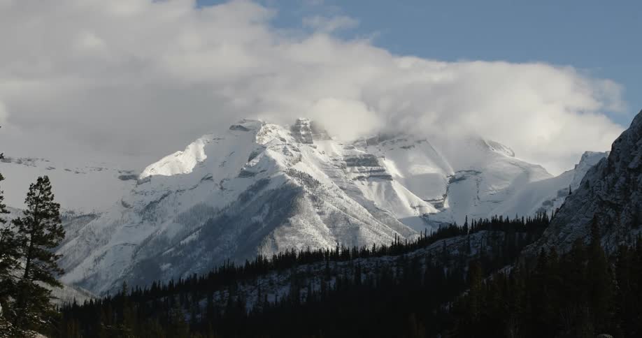 A still camera showing a cloud moving over a mountain