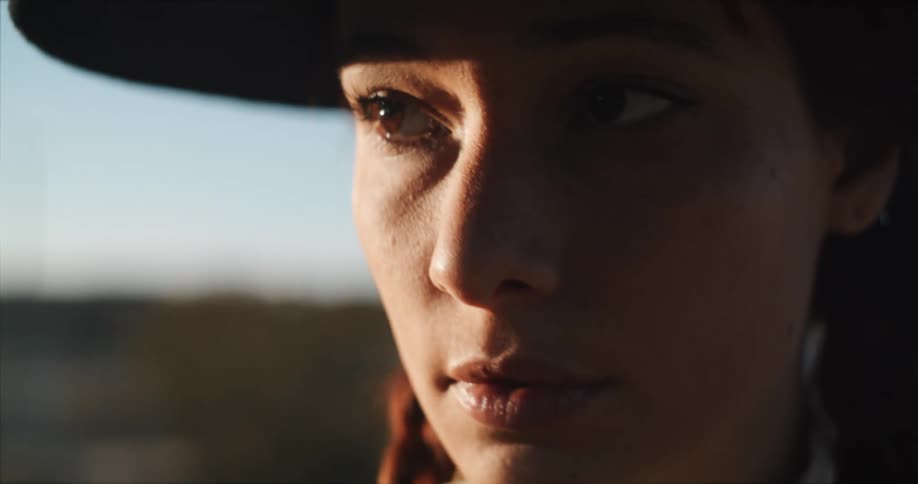 A woman stands outside in a field