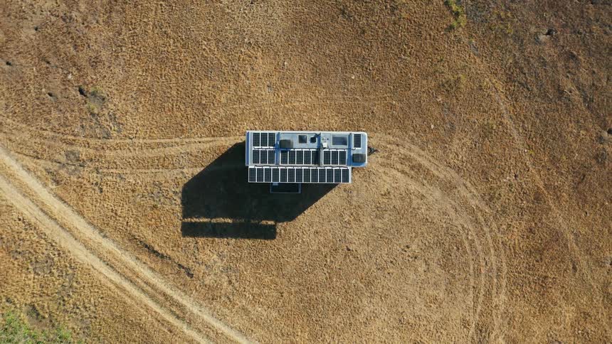 Solar panels top vehicle parked near dirt roads
