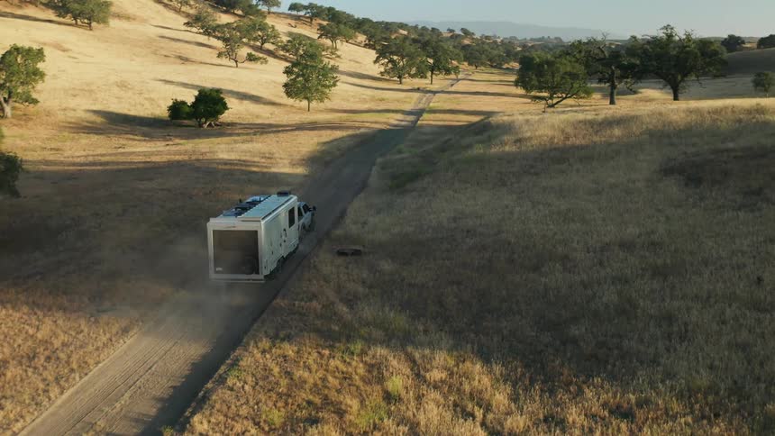 Aerial view of pickup truck with mobile home driving on country road