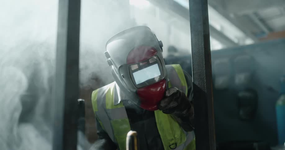 A man puts on the welders mask