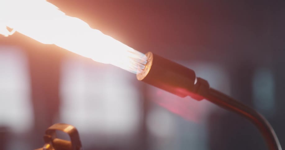 Person uses striker to start welding torch
