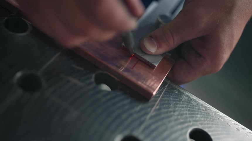 Hands tracing an edge onto wood