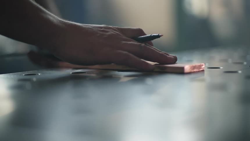 A person is measuring a piece of metal