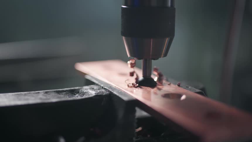 A drill is speeding up its incision inside the metal piece