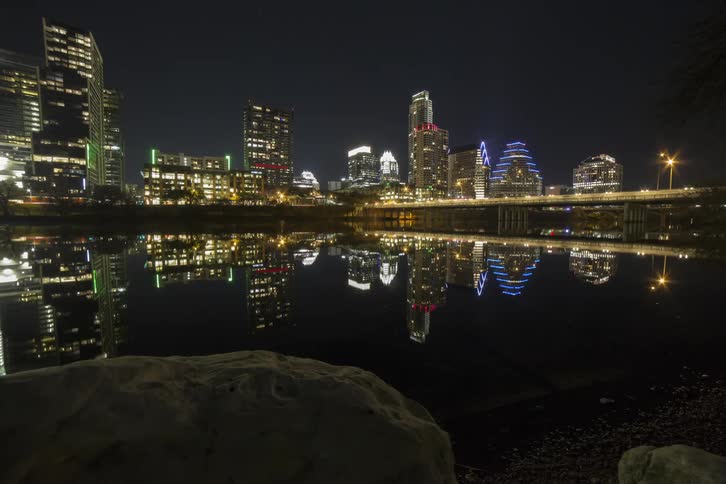 Beyond the water is a brightly lit city